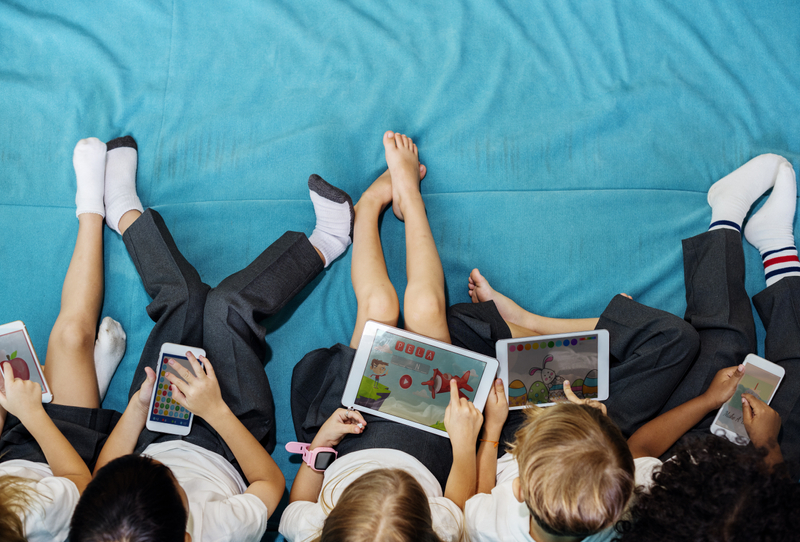 Children with tablets watching videos