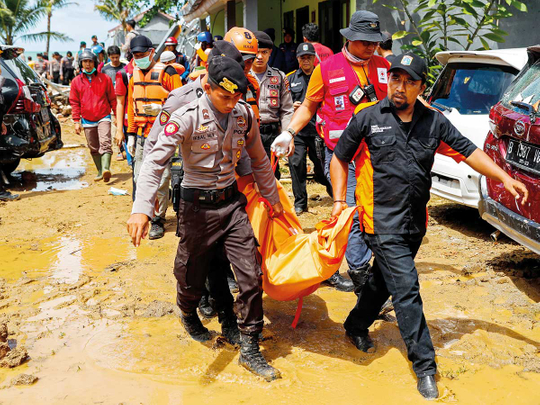 Rescue workers carry a body bag