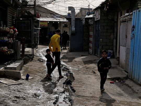Palestinian refugees walk in a street in the Baladiyat