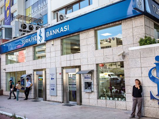 People stand outside a branch of Turkiye Is Bankasi AS