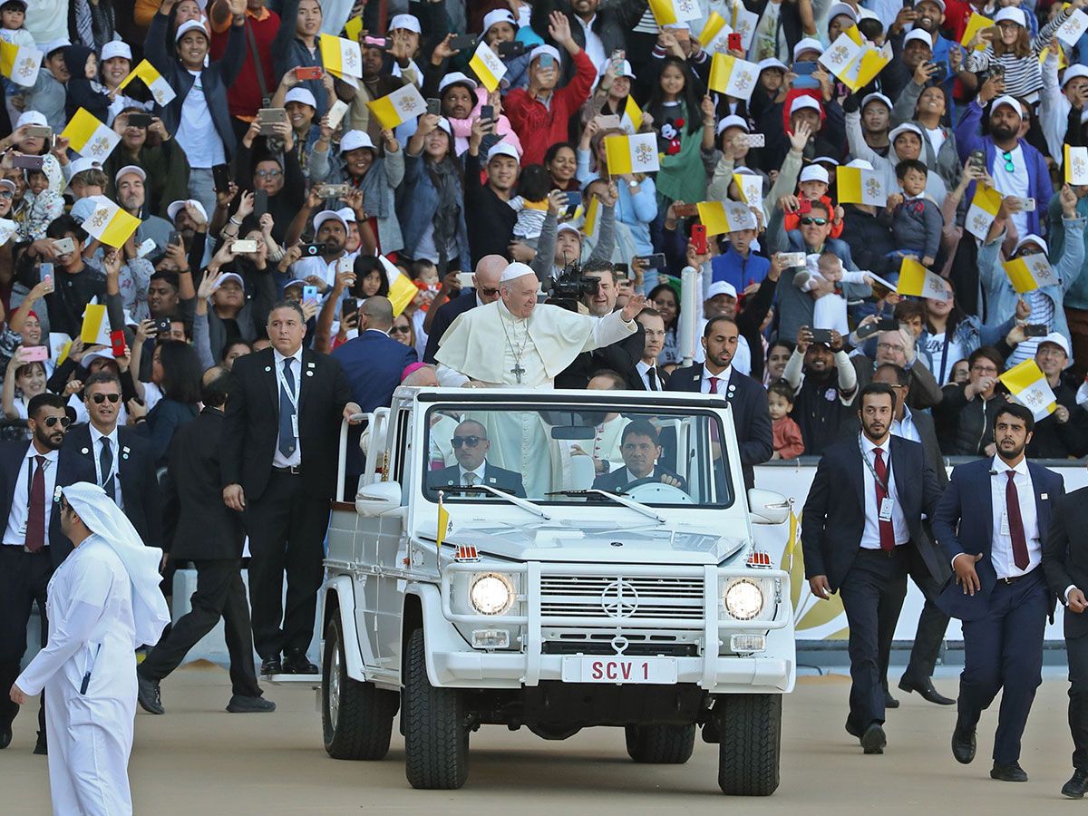 Pope Francis waves to the crowd as he arrives to lead mass