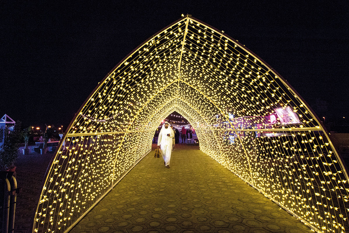 People take a walk under canopy of lights