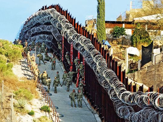 US Army troops install additional concertina wire