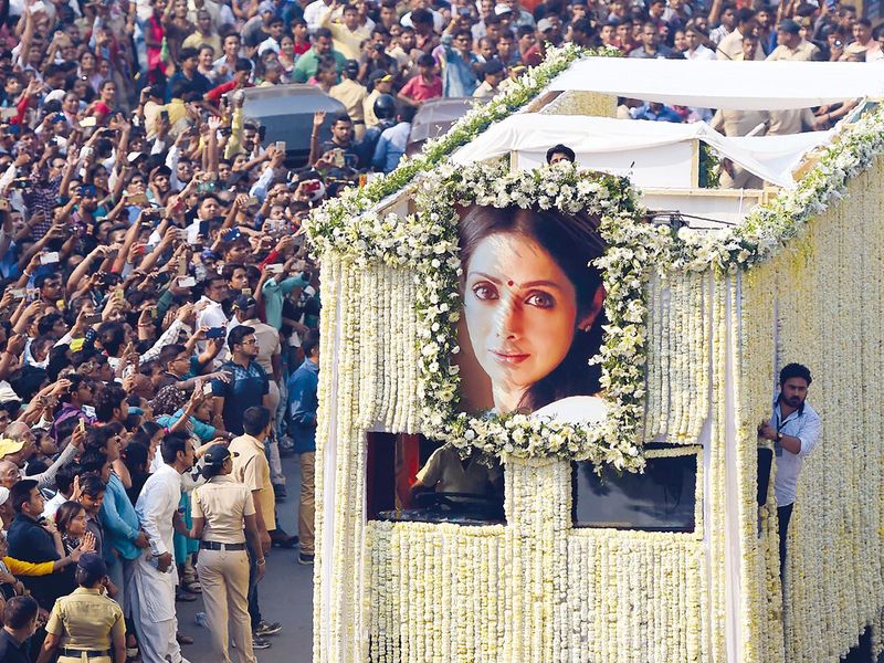 Fans watch as the funeral cortege for Sridevi passes through