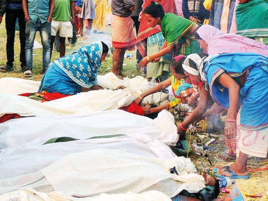Villagers attend to the bodies of victims