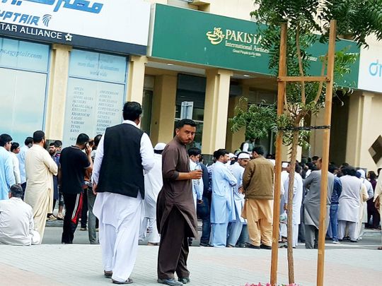 Scores of Pakistanis wait outside the PIA office
