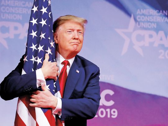 US President Donald Trump hugs American flag
