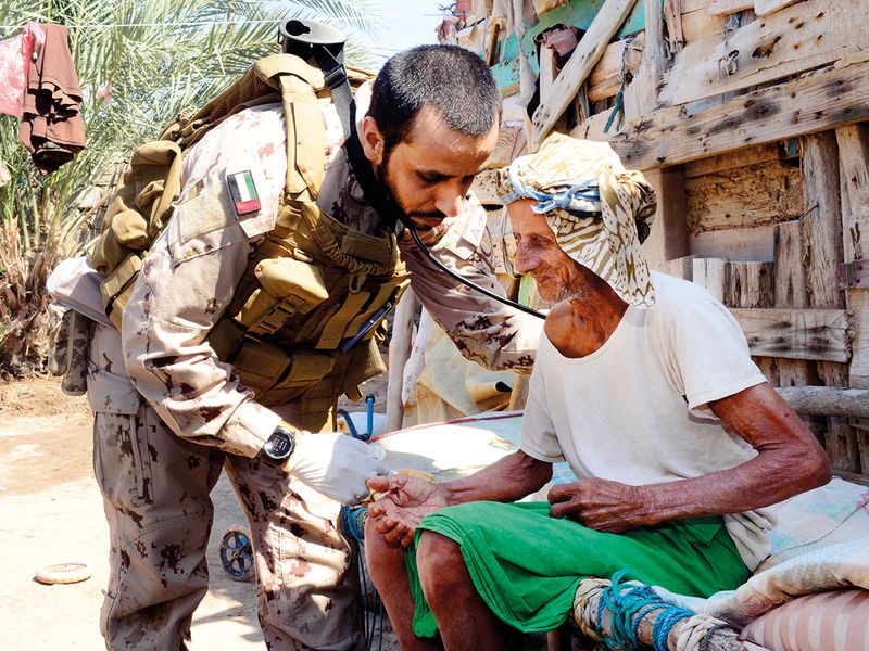 An UAE Armed Forces doctor checks an elderly Yemeni