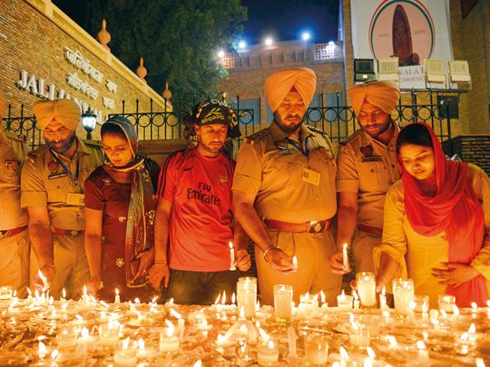 Punjab police officers light candles along with local residents