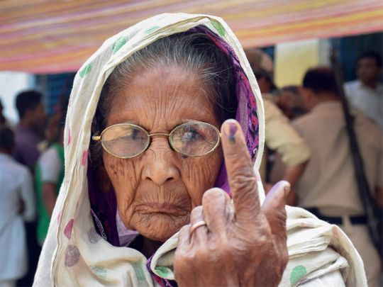An elderly woman shows her inked marked finger