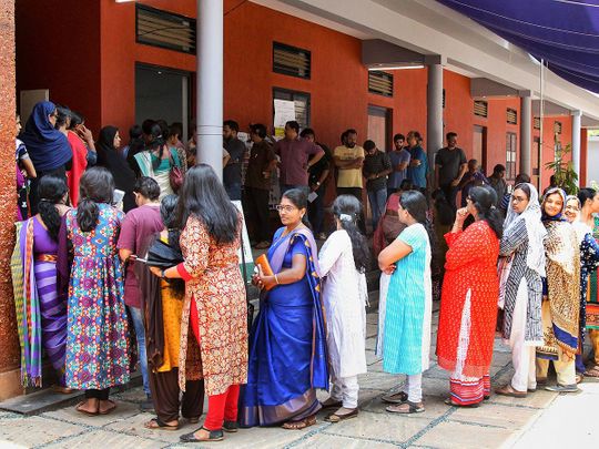 Women wait in a long queue to cast their votes