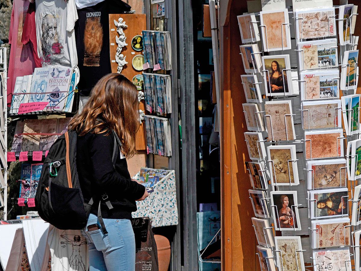 A tourist looks at a souvenirs shop in Vinci