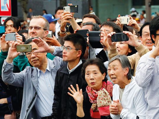People take pictures as the Japanese royal family