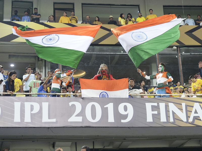 Cricket fans wave national tricolour flags