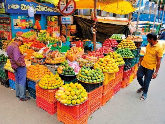Customers at a fruit stall in Bengaluru