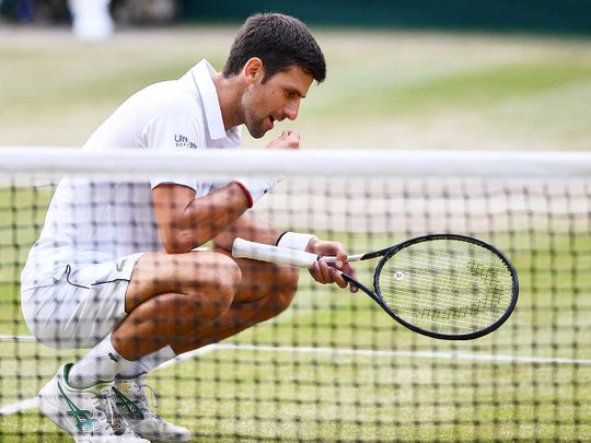 Serbia's Novak Djokovic eats a blade of grass 