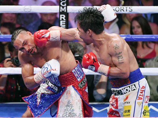 Manny Pacquiao (right) throws a right at Keith Thurman
