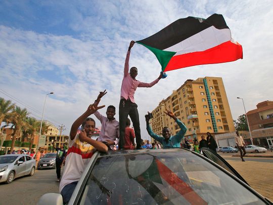  Sudanese protesters wave their national flag