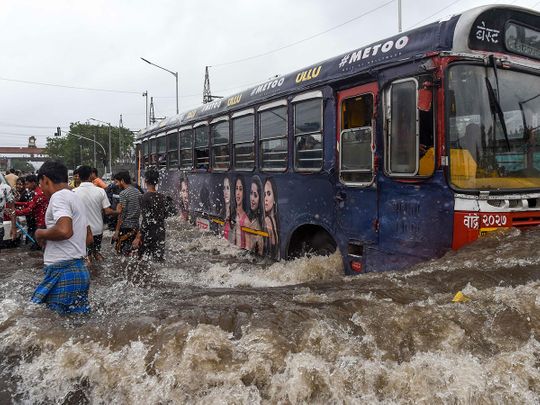 A public bus makes its way on a flooded road 