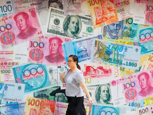 A woman walks by a money exchange in Hong Kong