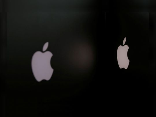 Apple company logos are seen as two MacBooks