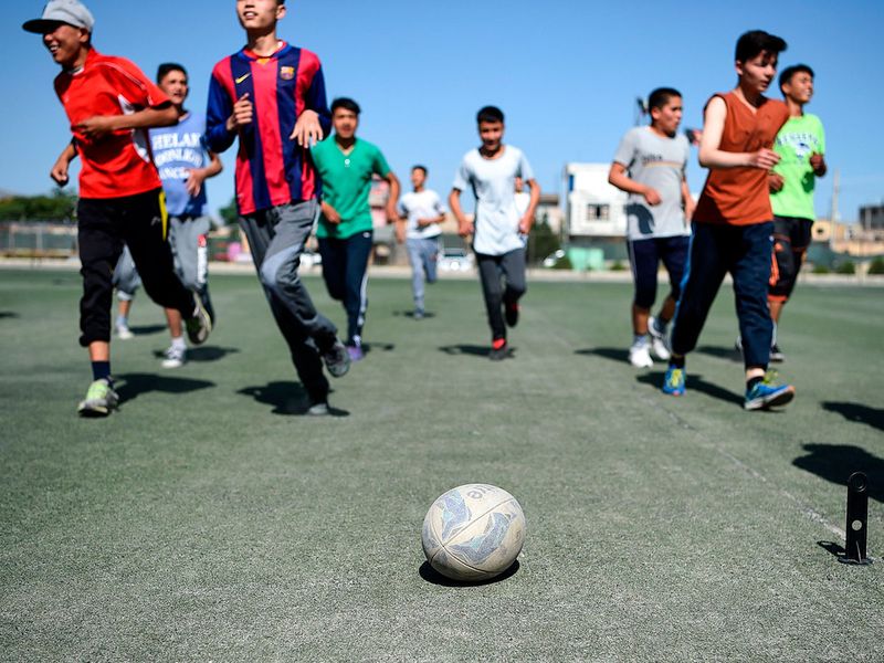 Young rugby players take part in a practice session on a pitch in Kabul