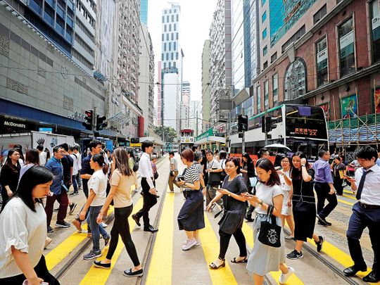 People cross a street in Hong Kong