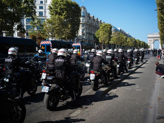 Motorcycle police officers drive along the Champs Elysees 