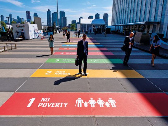 People walk along a plaza at United Nations Headquarters