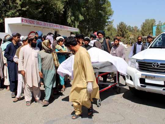 Villagers carry a dead body on a stretcher