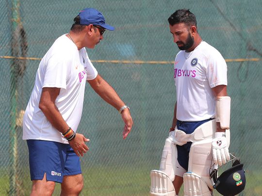 India's Cheteshwar Pujara, right listens to head coach Ravi Shastri 