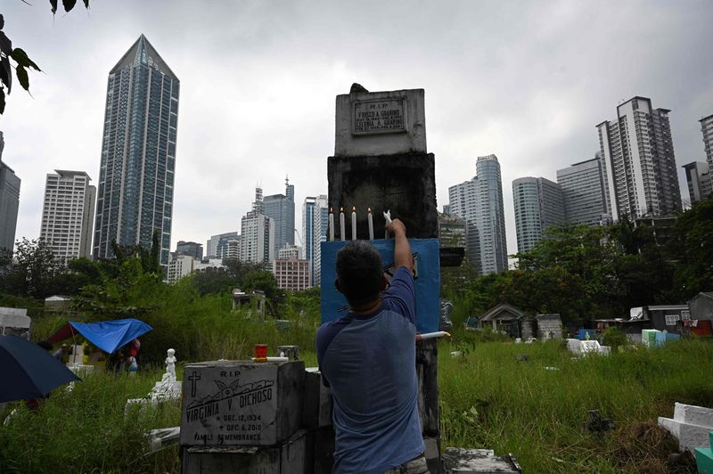 Filipinos pack cemeteries to remember the dead