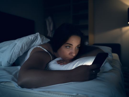 Woman in bed, phone