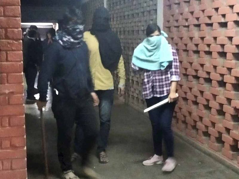 Masked miscreants armed with sticks roaming around campus, at JNU, New Delhi, Sunday.