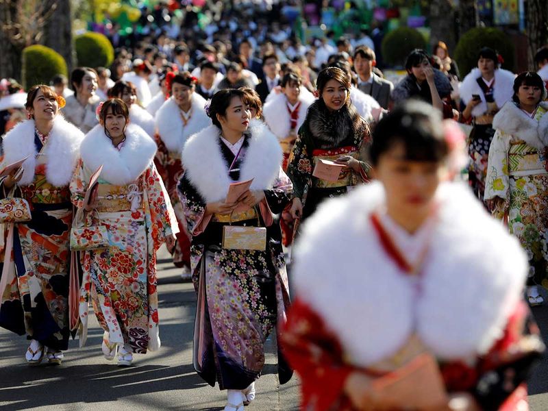 Japanese women wearing kimonos take selfies.  