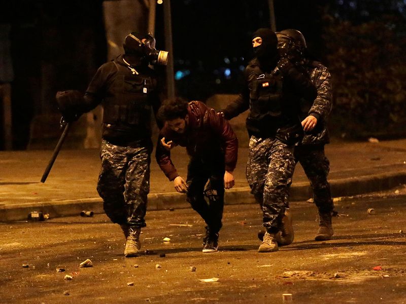 Lebanese police arrest an anti-government protester after dispersing a protest in Beirut, Lebanon. 