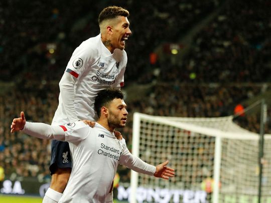 Liverpool's Alex Oxlade-Chamberlain, bottom, celebrates with Roberto Firmino after scoring his side's second goal against West Ham