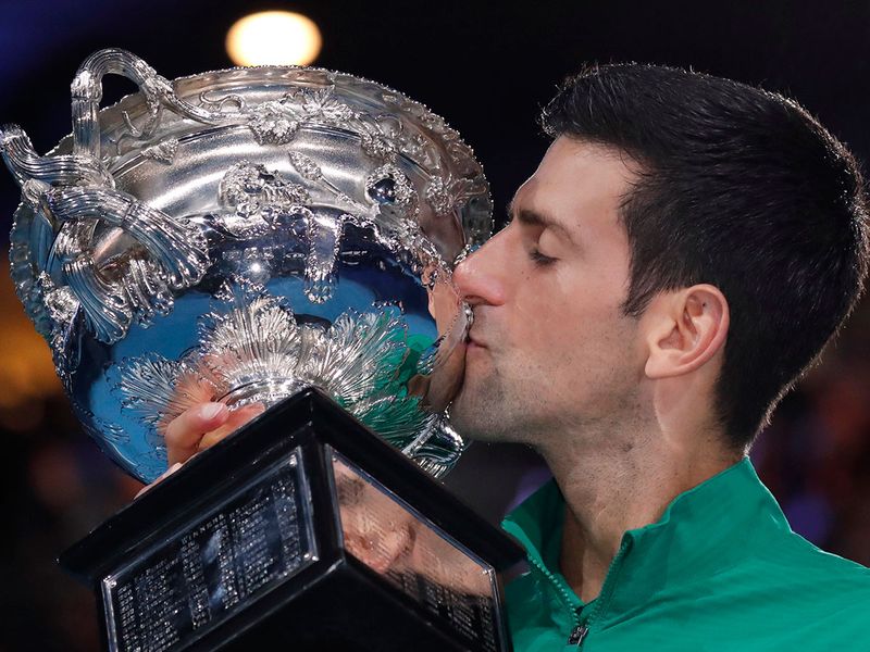 Serbia's Novak Djokovic kisses the Norman Brookes Challenge Cup after defeating Austria's Dominic Thiem in the men's singles fina