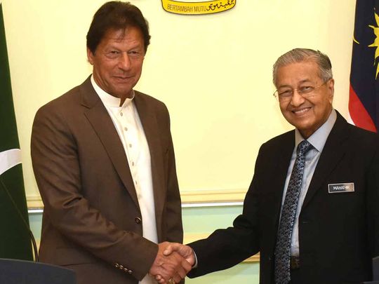Pakistan's Prime Minister Imran Khan shakes hands with Malaysia's Prime Minister Mahathir Mohamad after a joint news conference, Tuesday, Feb. 4, 2020, in Putrajaya, Malaysia