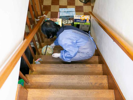 A woman, a medical researcher who asked not to be named, brings food to her husband and son who are self-quarantined in the basement of their home in Massachusetts on Feb. 4, 2020.