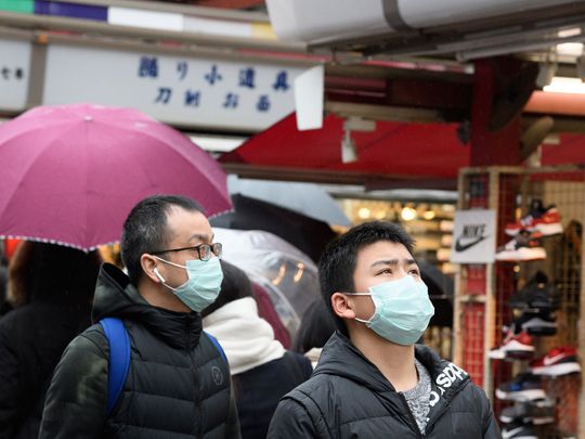 Pedestrians wear face masks on the streets of Tokyo