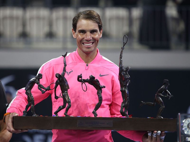 Rafael Nadal of Spain (R) holds his trophy after winning an exhibition game against compatriot David Ferrer (unseen) to inaugurate the Rafa Nadal Academy Kuwait, at Shaikh Jaber Al Abdullah Al Jaber Al Sabah International Tennis Complex in the Kuwaiti capital, on February 5, 2020.  / AFP / Yasser Al-Zayyat
