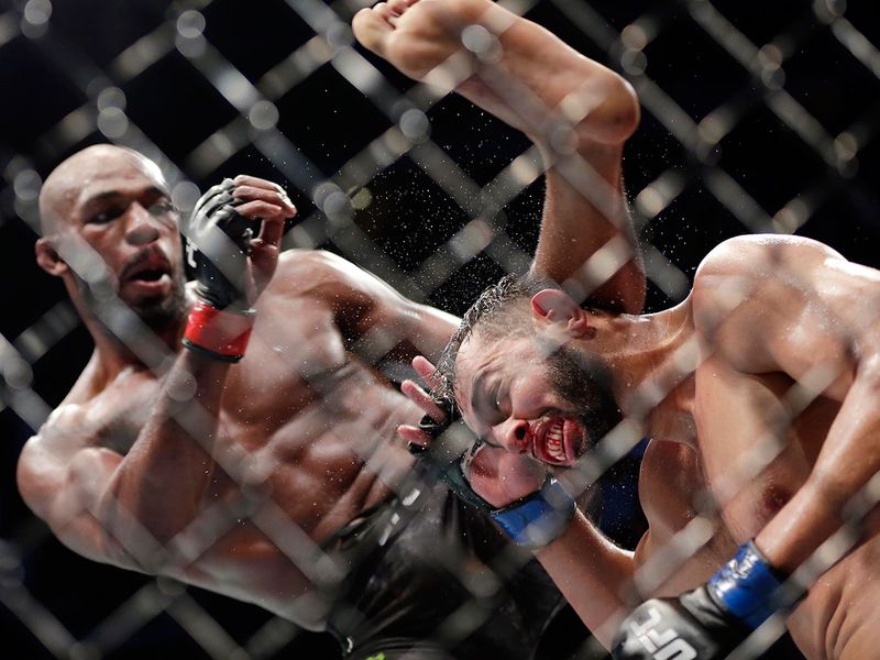 Jon Jones, left, delivers a kick to Dominick Reyes, right, during a light heavyweight mixed martial arts bout at UFC 247 Sunday, Feb. 9, 2020, in Houston. (AP Photo/Michael Wyke)