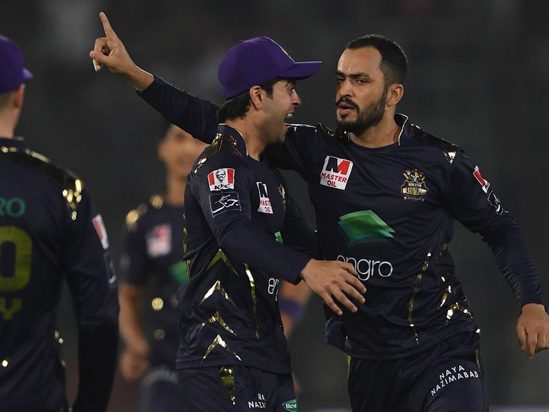 Mohammad Nawaz (R) of Quetta Gladiators celebrates with teammate Ahmed Shehzad (C) after taking the wicket of Colin Munro of Islamabad United during the Pakistan Super League (PSL) Twenty20 cricket match between Quetta Gladiators and Islamabad United at The National Cricket Stadium in Karachi on February