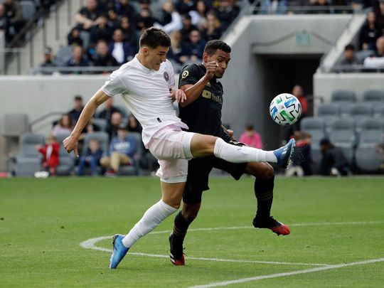 Inter Miami CF's Robbie Robinson, left, shoots as Los Angeles FC's Eddie Segura defends during the first half of an MLS soccer match Sunday, March 1, 2020, in Los Angeles. (AP Photo/Marcio Jose Sanchez)