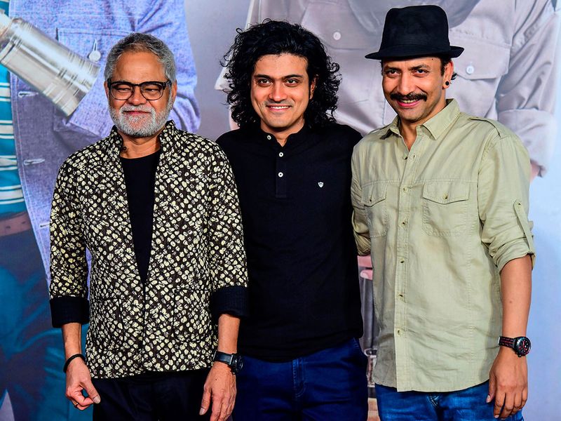 Bollywood actors Sanjay Mishra (L) and Deepak Dobriyal (R) along with film director Hardik Mehta pose for photographs as they attend the premiere of their Hindi drama film. 