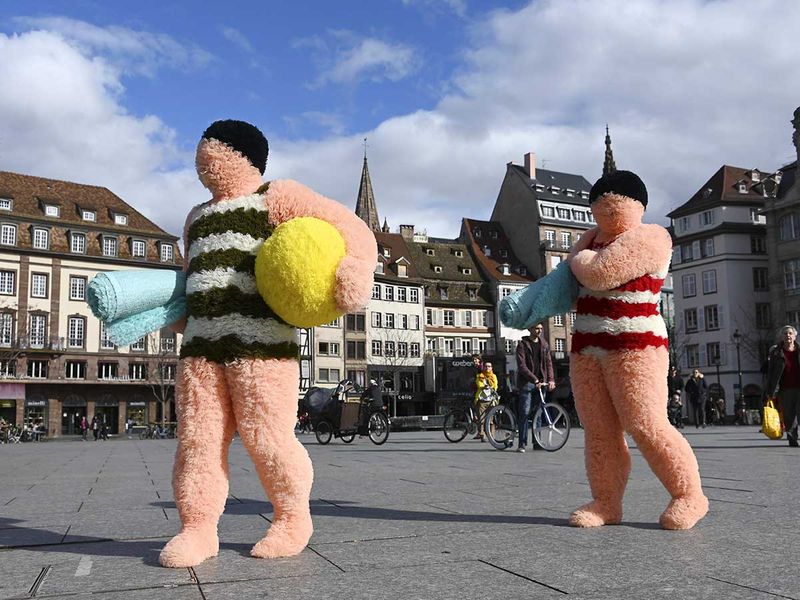 French artists Coco Petitpierre and Yvan Cledat, equipped with a beach ball and towels, take part in a creative performance called 