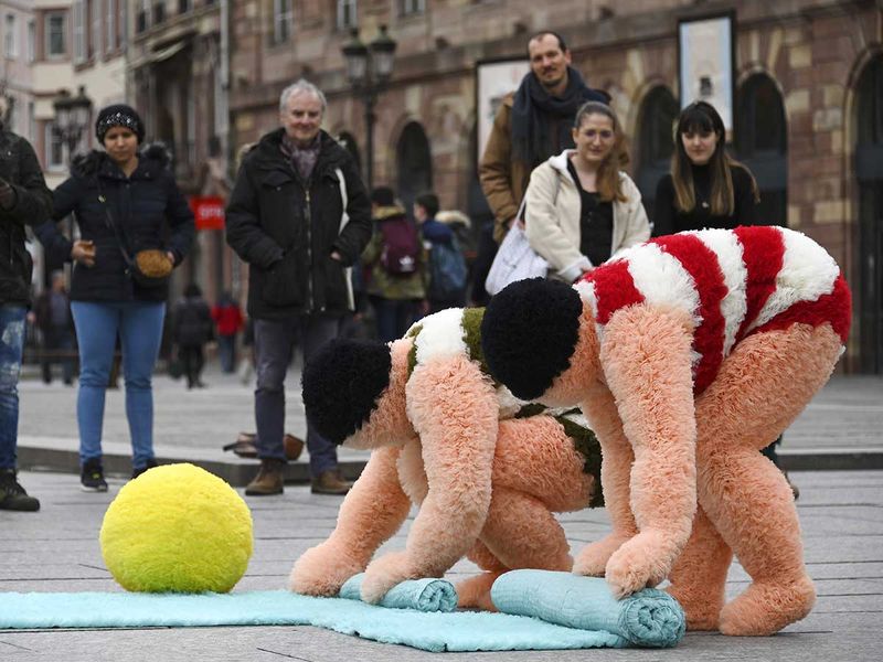 French artists Coco Petitpierre and Yvan Cledat, equipped with a beach ball and towels, take part in a creative performance called 