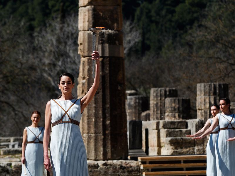 Greek actress Xanthi Georgiou, playing the role of the High Priestess, holds up the torch during the flame lighting ceremony at the closed Ancient Olympia site, birthplace of the ancient Olympics in southern Greece, Thursday, March 12, 2020. Greek Olympic officials are holding a pared-down flame-lighting ceremony for the Tokyo Games due to concerns over the spread of the coronavirus. Both Wednesday's dress rehearsal and Thursday's lighting ceremony are closed to the public, while organizers have slashed the number of officials from the International Olympic Committee and the Tokyo Organizing Committee, as well as journalists at the flame-lighting. (AP Photo/Thanassis Stavrakis)