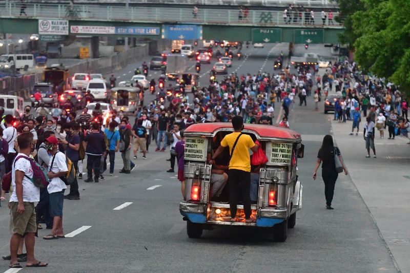 Filipino workers waiting for public transport early on Monday, March 16, 2020.